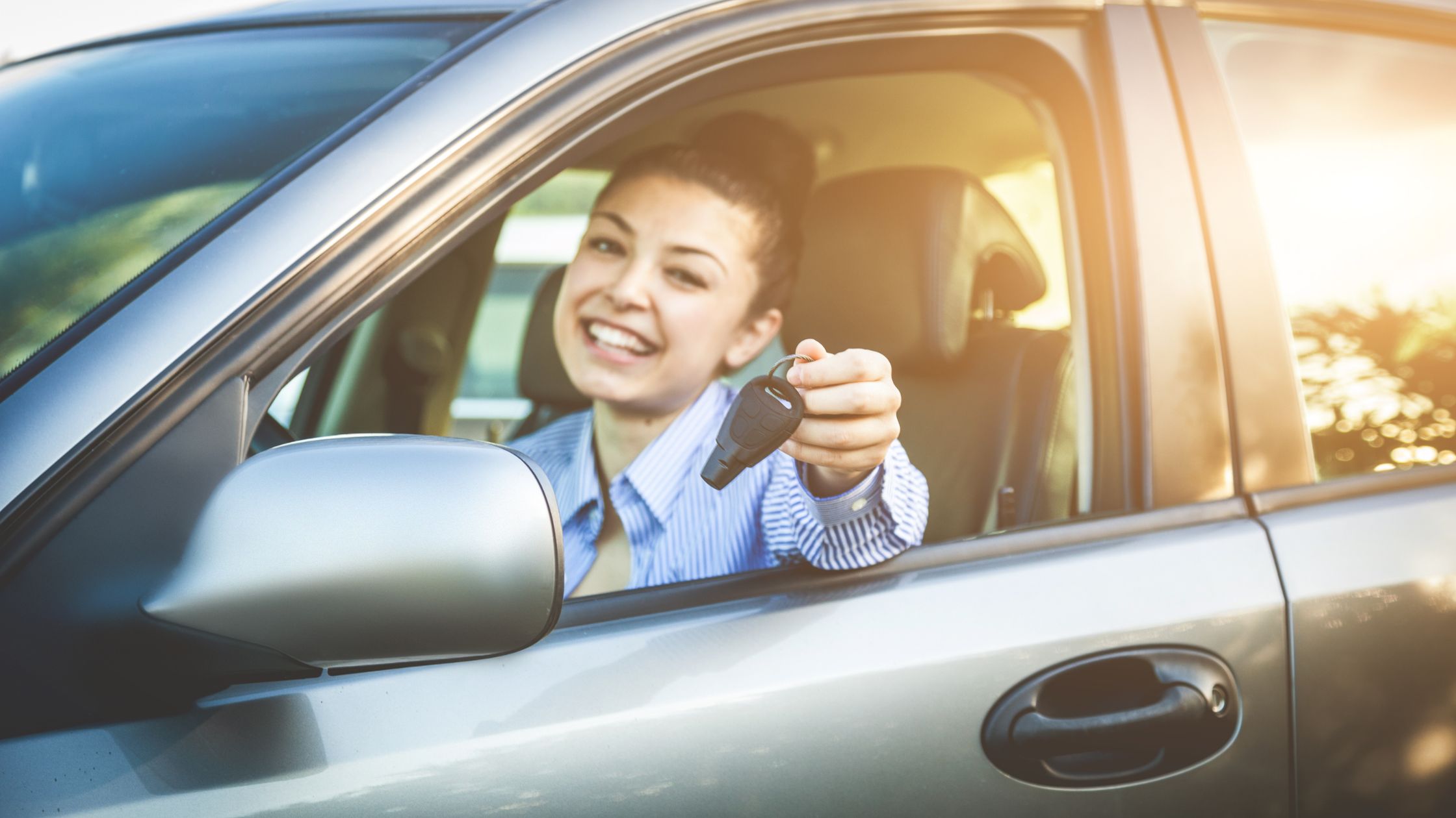 Tips for buying your first car: A teenager takes delivery of her first car.